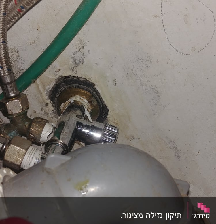 צינורות מים, ברזים וחיבורים מתכתיים מתחת לכיור